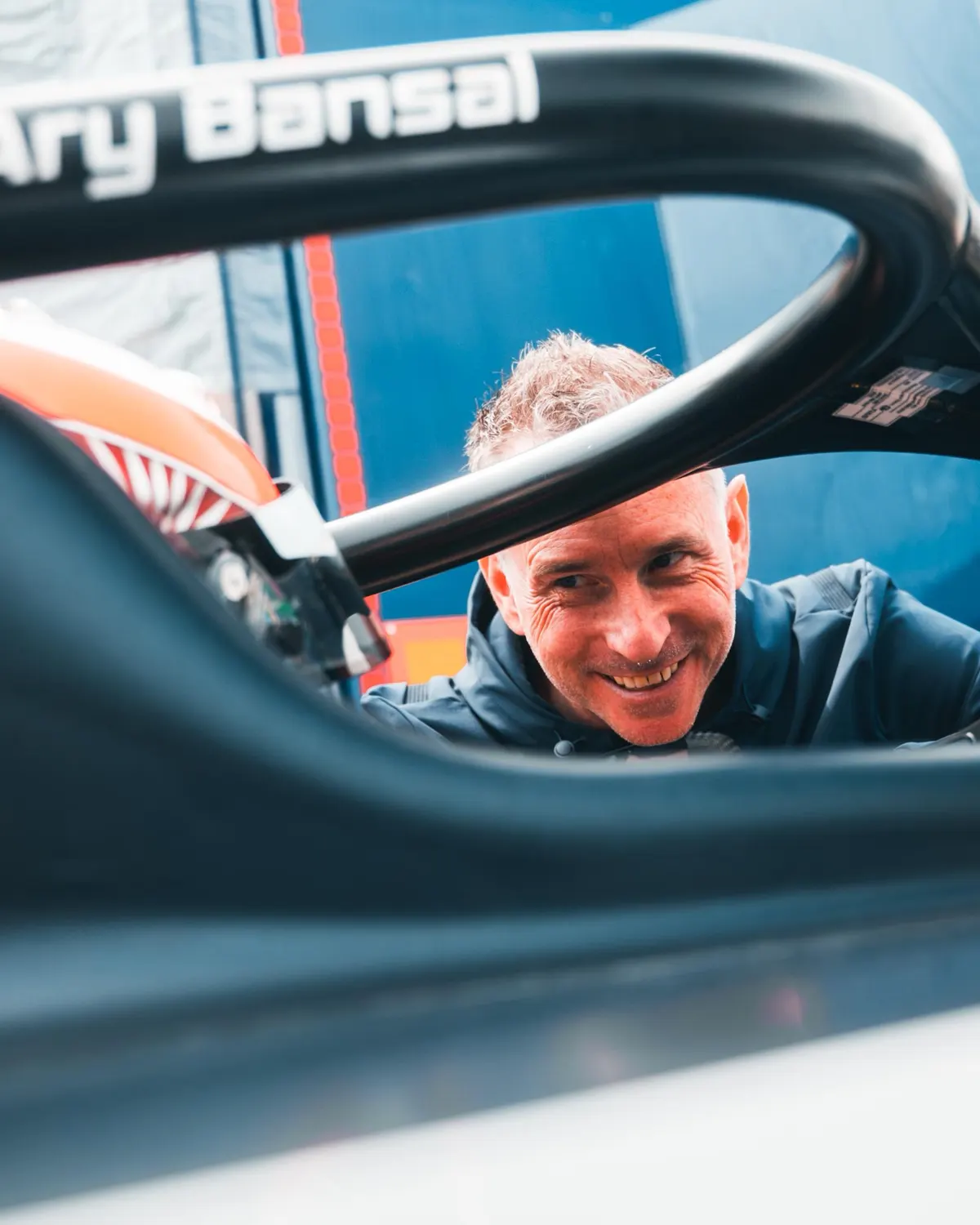 Danny Watts smiling as he looks into the cockpit of a single-seater